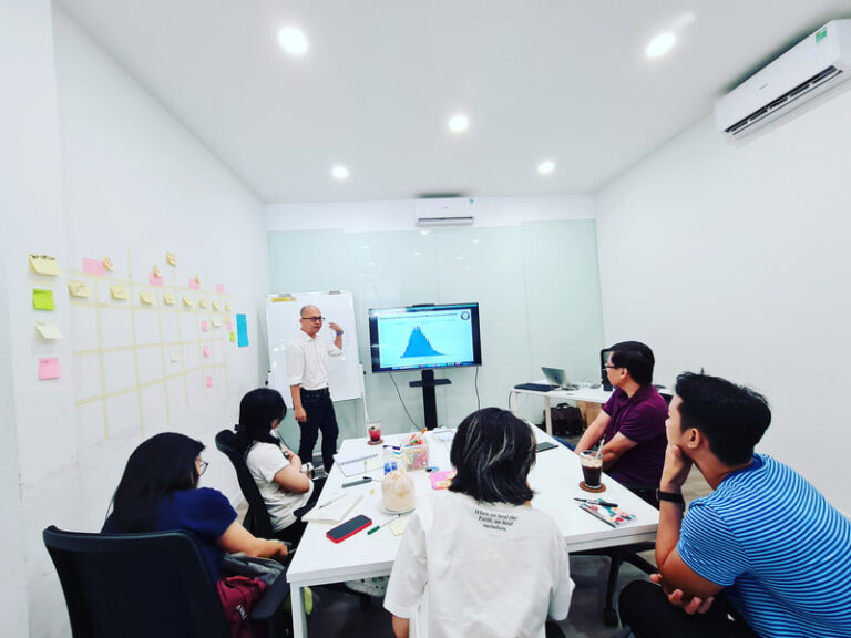 Trainer giảng bài bên màn hình và tường note