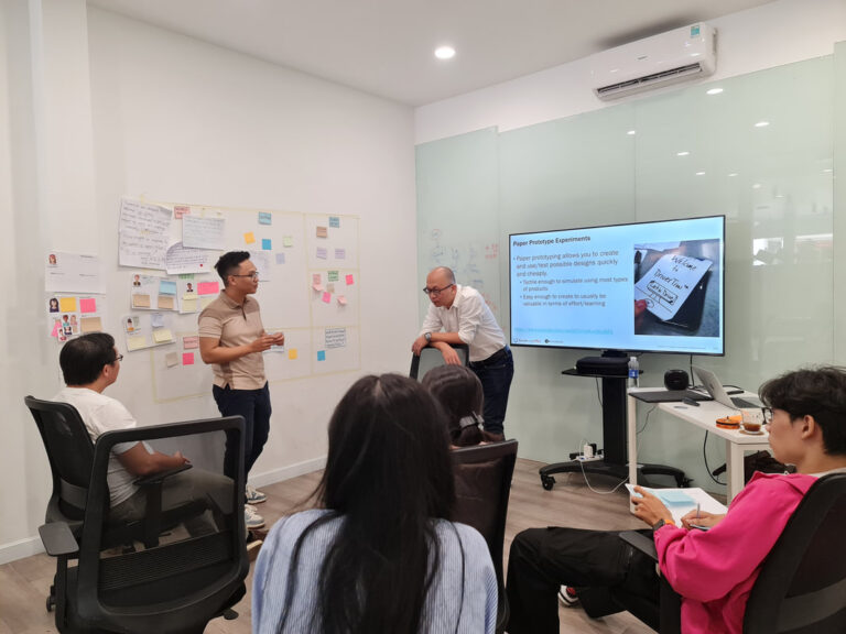Trainer giảng bài cạnh màn hình