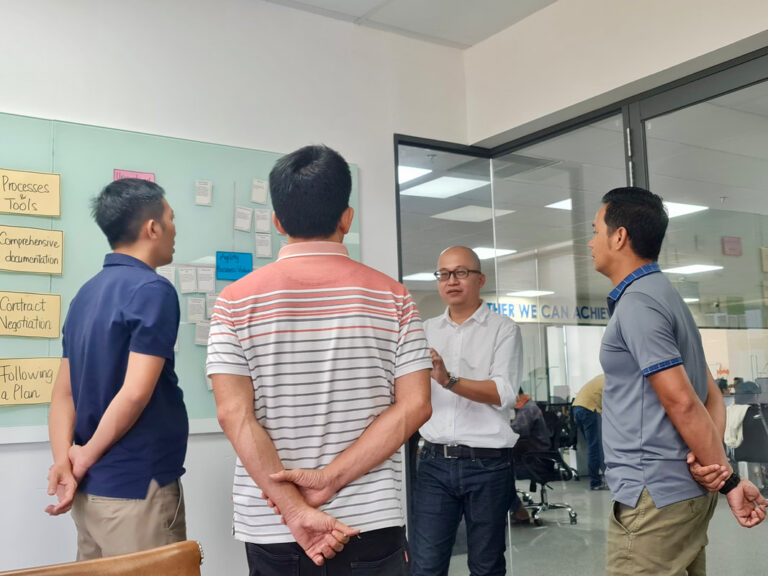 Trainer trao đổi với các học viên đứng quanh