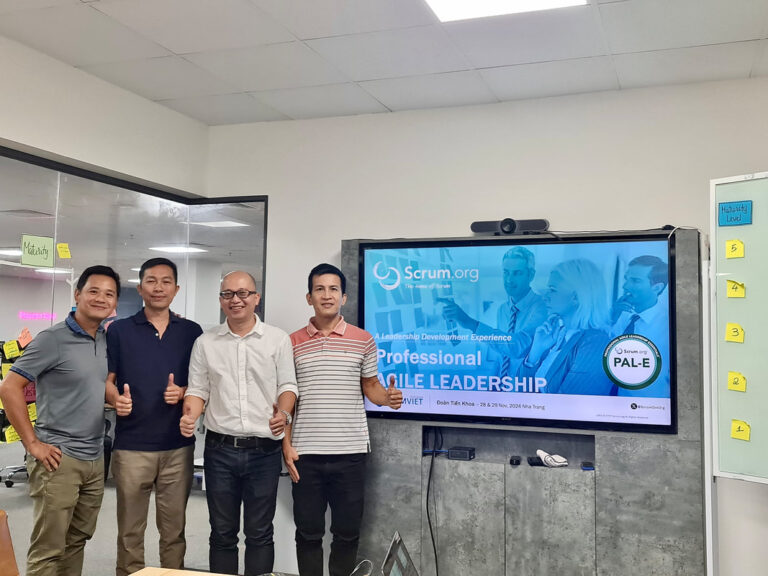 Học viên chụp ảnh cùng trainer trước màn hình Professional Agile Leadership Essentials