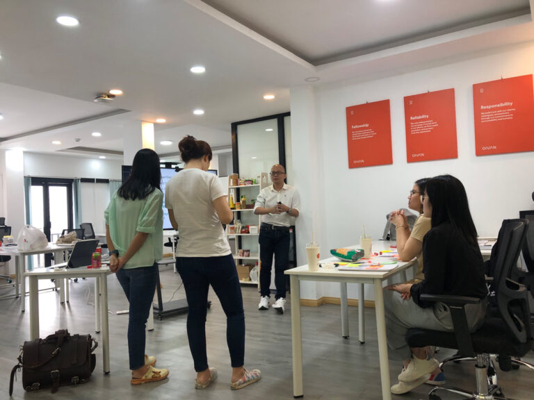 Học viên đứng trao đổi quanh bàn